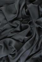 tissu soyeux en satin abstrait, drapé en tissu avec plis ondulés.avec des vagues douces, ondulant dans le vent.texture de papier froissé photo