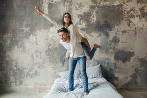 Jeune content souriant couple séance sur lit à Accueil photo