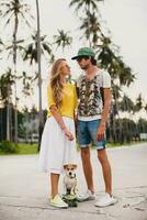 Jeune élégant branché couple dans l'amour sur vacances avec chien et planche à roulette, photo