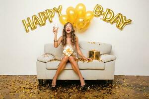 jolie femme célébrer fête dans d'or confettis photo