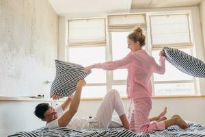 Jeune couple ayant amusement sur lit dans Matin photo