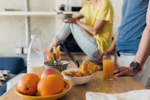 Jeune attrayant couple de homme et femme cuisine petit déjeuner ensemble dans Matin à cuisine photo