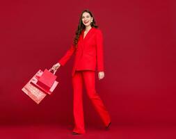 attrayant femme dans rouge avec achats Sacs vente sur rouge Contexte photo