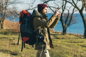 Jeune branché homme en voyageant avec sac à dos dans du froid saison photo