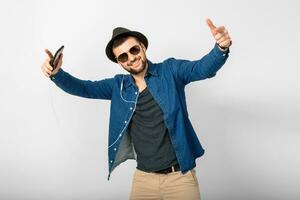 Jeune Beau content souriant homme écoute à la musique dans écouteurs photo