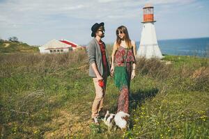 Jeune élégant branché couple dans l'amour en marchant avec chien dans campagne photo