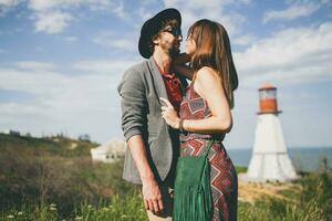 souriant en portant mains Jeune branché couple indie style dans l'amour en marchant dans campagne photo