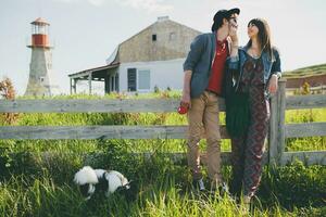 élégant branché couple dans l'amour en marchant avec chien dans campagne photo