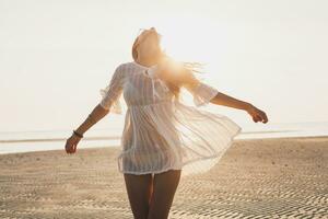 svelte magnifique femme dans blanc coton robe en marchant sur tropical plage photo