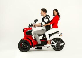 Jeune attrayant couple équitation un électrique moto scooter content ayant amusement ensemble photo