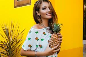 attrayant souriant femme sur vacances en portant ananas photo