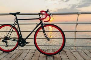 branché vélo dans Matin lever du soleil par le mer photo