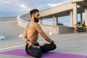 attrayant beau homme avec athlétique fort corps Faire Matin yoga asana en plein air photo