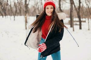 souriant femme ayant amusement dans hiver parc photo