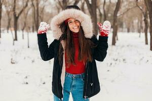 souriant femme ayant amusement dans hiver parc photo