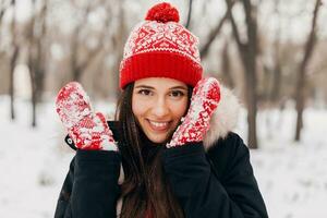 souriant femme ayant amusement dans hiver parc photo