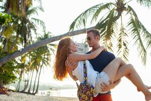 Jeune couple dans l'amour content sur été plage ensemble ayant amusement photo