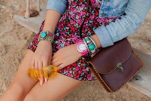 élégant femme dans vacances sur mains de plage avec coloré Jaune soleil accessoires bijoux et sac photo