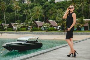 luxe sexy attrayant femme habillé dans romantique noir robe posant sur jetée dans luxe recours Hôtel photo