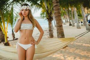 Jeune sexy femme dans blanc bikini maillot de bain sur tropical plage photo