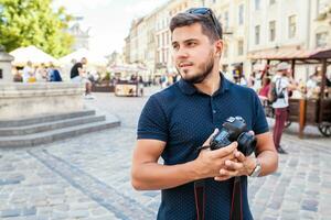 Jeune Beau branché homme en marchant avec photo caméra