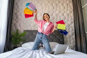 femme sauter sur lit à Accueil avec achats Sacs achats en ligne photo