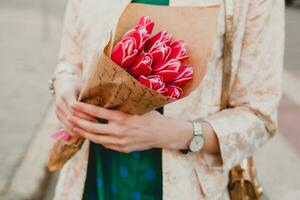 mains de élégant femme en portant fleurs bouquet photo