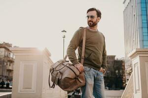 branché homme en marchant dans rue avec sac photo