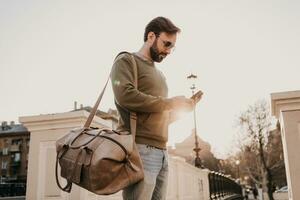 branché homme en marchant dans rue avec sac photo