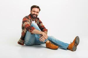 Beau barbu homme dans branché tenue habillé dans jeans et à carreaux chemise photo