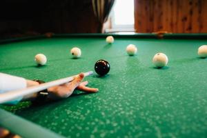 jeune homme élégant dans un costume sombre joue au billard photo