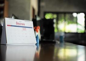 calendrier agrandi sur la table avec lumière bokeh floue en arrière-plan. concept de travail à domicile. mot thaï sur le calendrier signifie juin en anglais