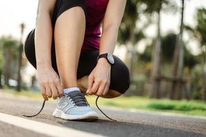 gros plan du coureur de la jeune femme attachant ses lacets. concept de santé et de remise en forme. photo