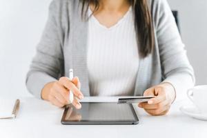 femme utilisant une tablette numérique avec une carte de crédit. achats en ligne, finances, publicité en ligne. photo