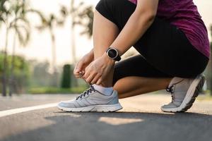 gros plan du coureur de la jeune femme attachant ses lacets. concept de santé et de remise en forme. photo