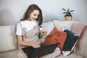 jeune femme millénaire faisant des achats en ligne à la maison. photo