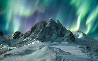 aurores boréales sur la montagne majestueuse dans la neige sur l'île de segla photo