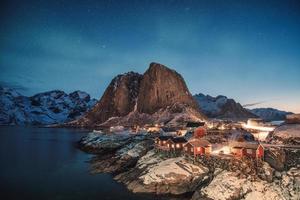 aurores boréales sur la montagne avec village de pêcheurs à hamnoy photo