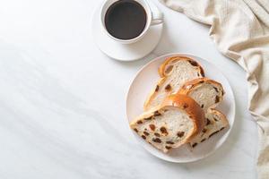 pain aux raisins avec une tasse de café pour le petit déjeuner photo