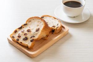 pain aux raisins avec une tasse de café pour le petit déjeuner photo