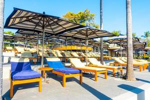 beau parasol et chaise de luxe autour de la piscine extérieure de l'hôtel et du complexe avec cocotier pour le concept de voyage et de vacances photo