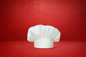 blanc du chef chapeau sur rouge Contexte. du chef chapeau. photo