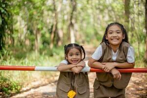 asiatique peu les filles explorer la nature par grossissant des lunettes et jumelles dans le parc. éducation, champ voyages, recherche, et Découverte concepts. photo