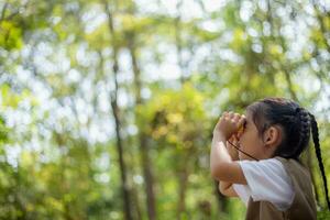 content peu asiatique les filles à la recherche devant et souriant enfant avec le jumelles dans le parc. Voyage et aventure concept. liberté, vacances photo