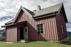 belle cabane en bois rouge sur la colline dans la nature de la norvège. photo