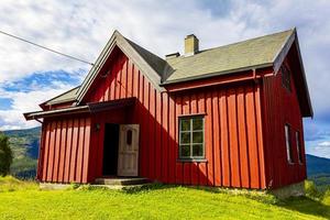 belle cabane en bois rouge sur la colline dans la nature de la norvège. photo