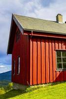 belle cabane en bois rouge sur la colline dans la nature de la norvège. photo