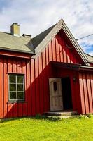 belle cabane en bois rouge sur la colline dans la nature de la norvège.