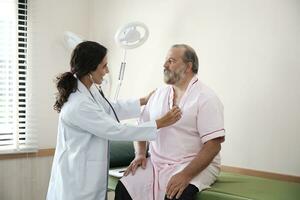 femelle médecins dans uniforme en bonne santé vérifier blanc Masculin les patients dans examen manteau par stéthoscope, et bilans et conseiller santé se soucier diagnostic à clinique hôpital, et rendez-vous visite. photo