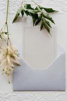 invitation de mariage dans une enveloppe grise avec des brins verts photo